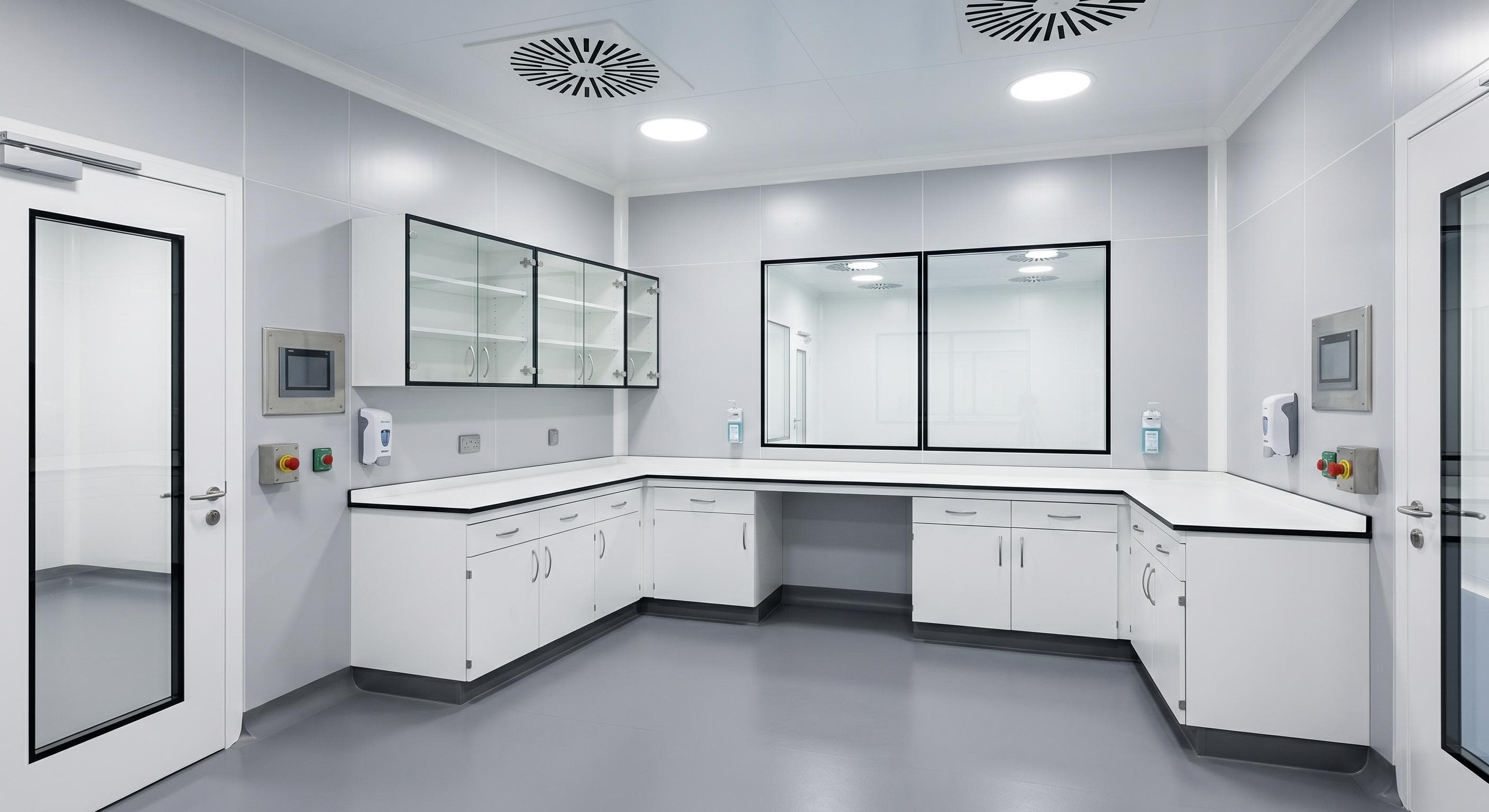 Sala blanca farmacéutica con instrumentación de control ambiental y pantallas de monitorización